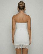 Back view of a woman wearing the Lauven Celeste Mini Dress, showcasing the strapless design and lace hem detail.