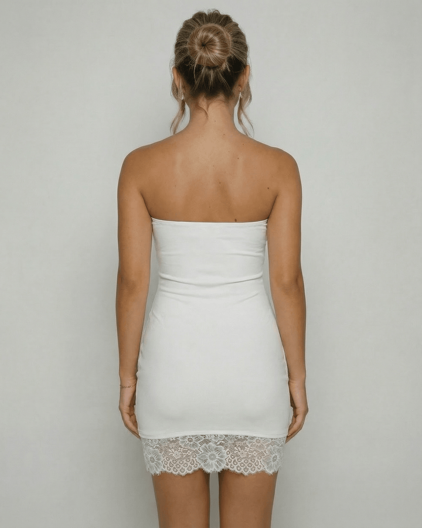 Back view of a woman wearing the Lauven Celeste Mini Dress, showcasing the strapless design and lace hem detail.