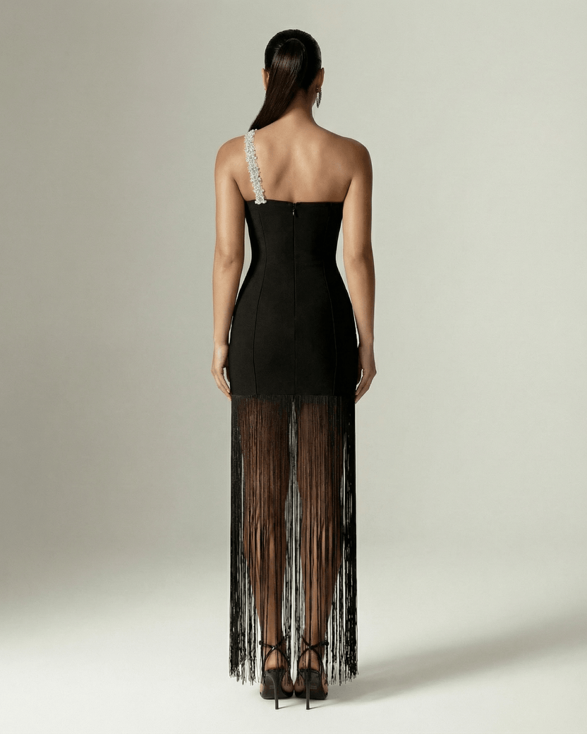 Back view of the Celestia Maxi Dress from Lauven, featuring a black one-shoulder design and elegant fringed hem.