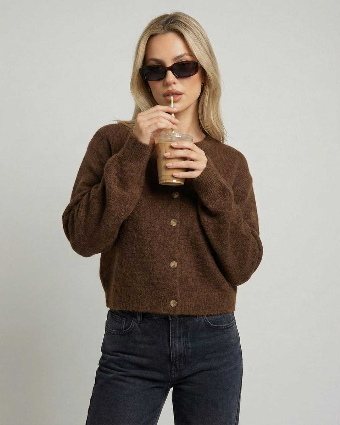 Woman wearing Cocoa Cardigan by Lauven, enjoying a drink, features button-front and relaxed fit.