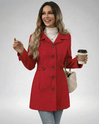 Woman wearing a Crimson Sculpt Jacket by Lauven, showcasing a stylish and tailored look with a coffee cup.
