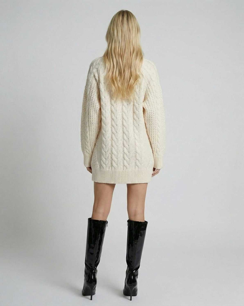 Back view of a model wearing the Eira Sweater by Lauven, showcasing its minimal cable-knit design and modern silhouette.