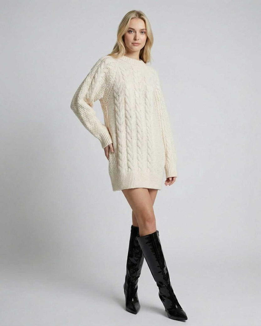 Eira Sweater by Lauven, a minimal cable-knit long sleeve sweater in cream, styled with knee-high black boots.