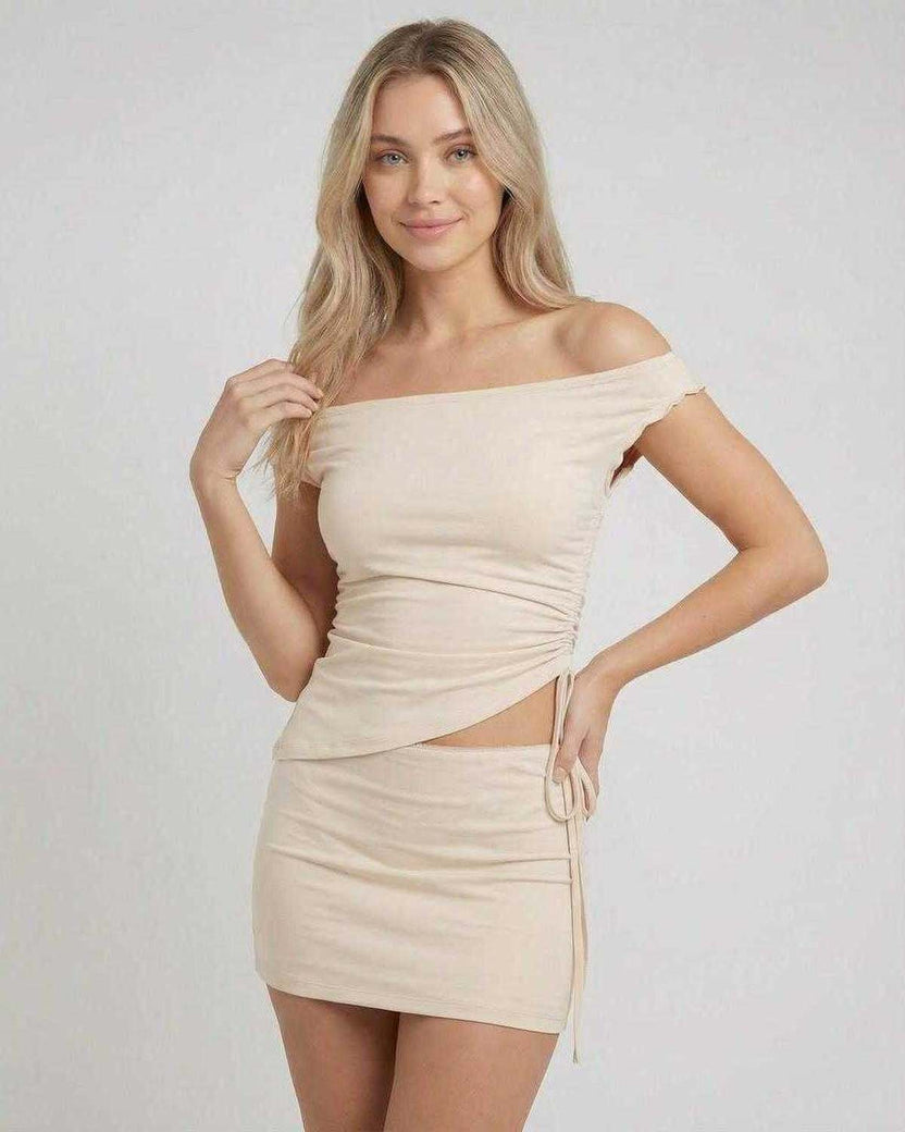Elysia Mini Dress by Lauven featuring asymmetric off-shoulder top and high waist mini skirt in a neutral tone.