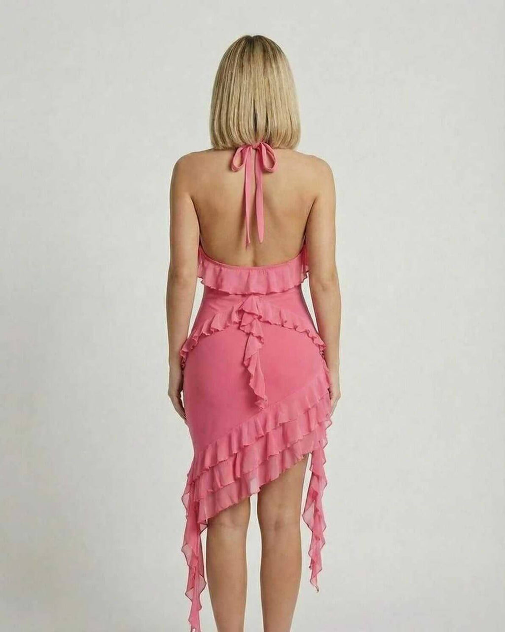 Flora Mini Dress by Lauven in soft pink with ruffle detail, showcasing a chic halter-neck design from the back.