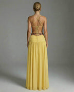 Back view of the Heliora Maxi Dress by Lauven, showcasing its yellow hue and elegant floor-length design.