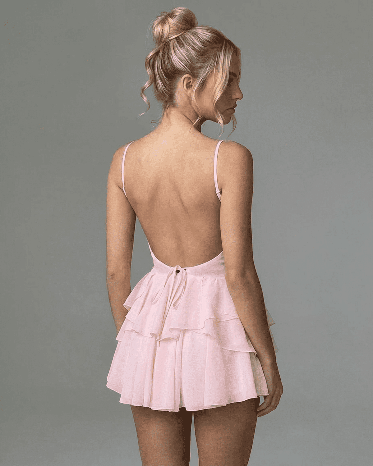 Isolde Mini Dress by Lauven, showcasing a back view of a pink ruffle design with spaghetti straps.