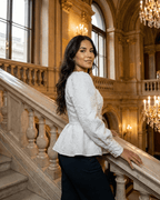 Ivory Corset Top modeled by a woman in an elegant setting, featuring jacquard fabric with puff sleeves and a square neckline.