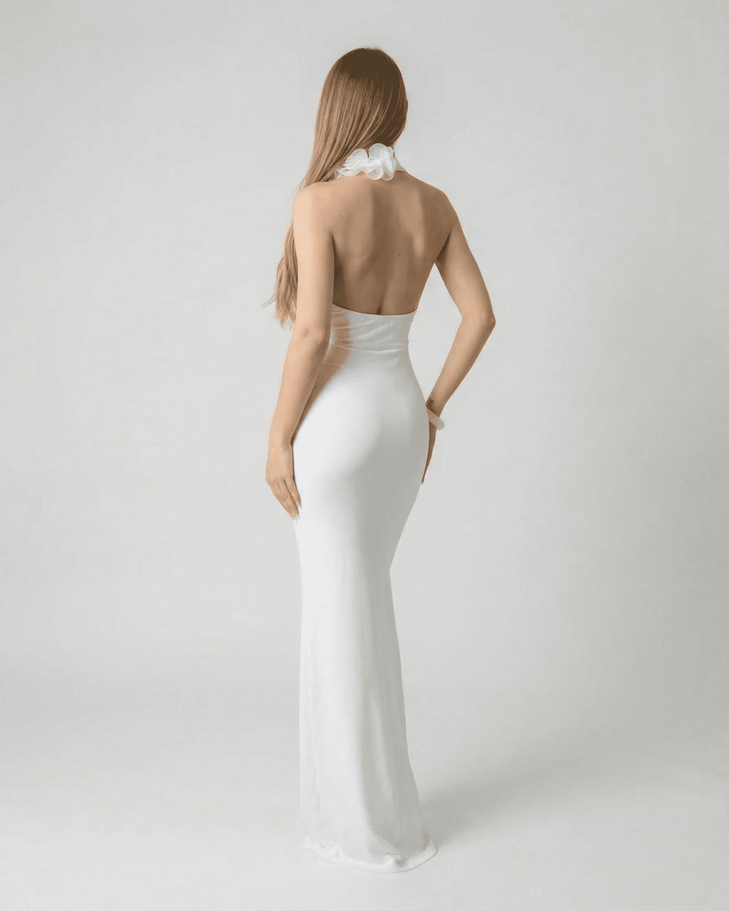 Lumière Maxi Dress by Lauven - Back view of a white deep V neck backless maxi dress with 3D floral detail.