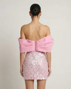 Lauven Luna Mini Dress in pink sequins, strapless with an elegant off-the-shoulder draped detail, showcasing the back view.
