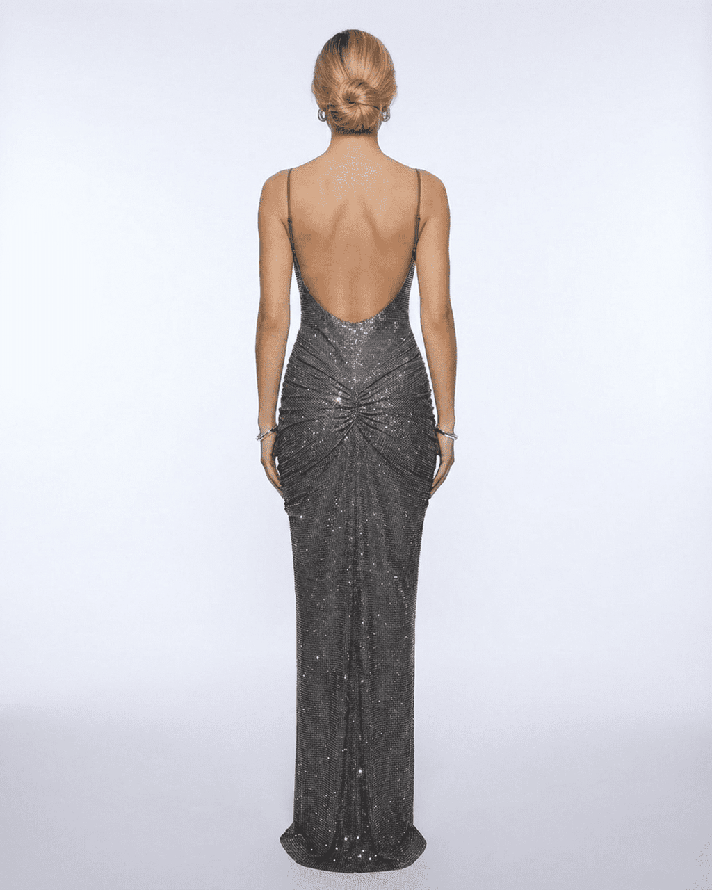 Back view of a woman wearing the Lyra Maxi Dress from Lauven, showcasing its metallic crystal embellishments and elegant silhouette.