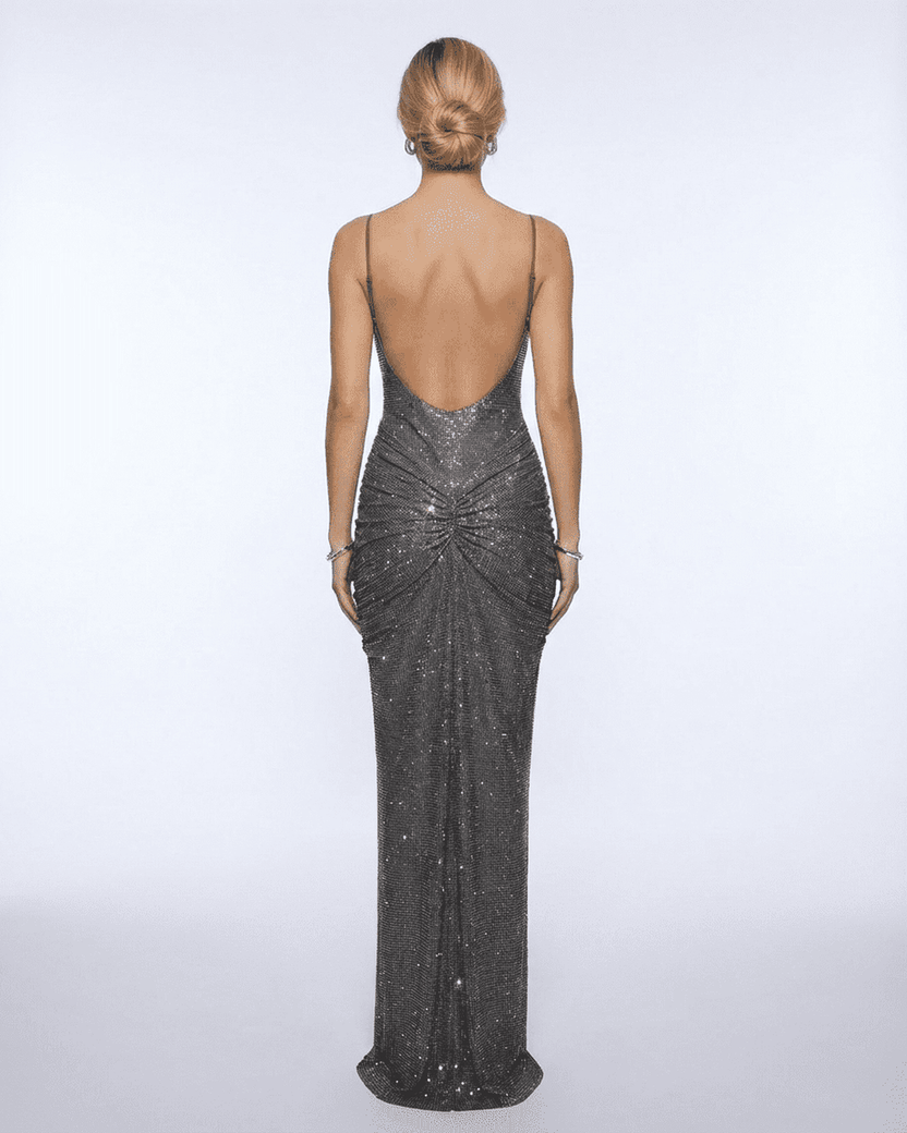 Back view of a woman wearing the Lyra Maxi Dress from Lauven, showcasing its metallic crystal embellishments and elegant silhouette.