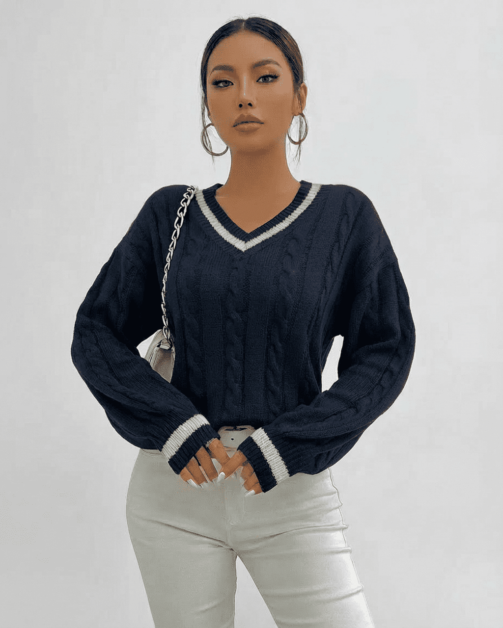 Model wearing the Marina Sweater by Lauven in navy, showcasing a cable knit design and V-neck collar.