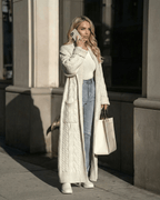 Milano Cardigan by Lauven worn by a woman in a city setting, showcasing long cable-knit wool blend layering.