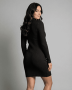 Model wearing Lauven Milano Mini Dress, black ribbed knit, mock neck, long sleeve, A-line silhouette from the back.
