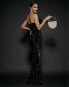 Elegant woman in the Noir Maxi Dress by Lauven, featuring sequins and a strapless design, perfect for evening events.