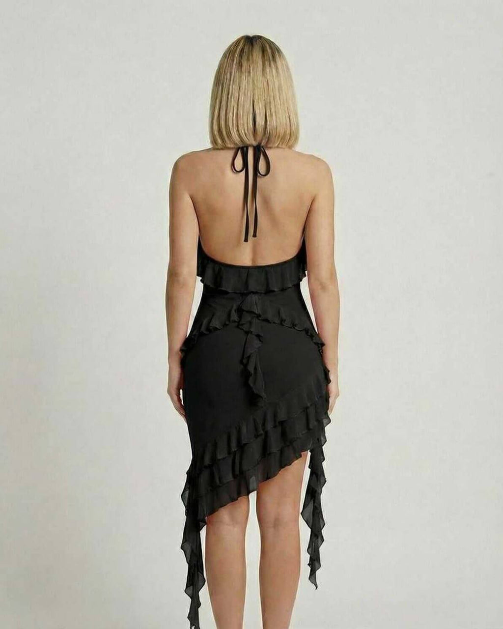 Back view of Lauven Noir Mini Dress featuring ruffle detail and asymmetrical hemline in classic black.