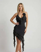 Model showcasing the Noir Mini Dress by Lauven, featuring ruffle details and an asymmetrical hemline in classic black.