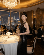Noiré Maxi Dress by Lauven worn in an elegant restaurant setting, showcasing backless design and floral sequins.