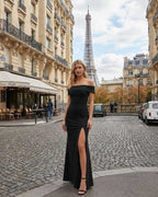 Noiré Maxi Dress by Lauven features a chic off shoulder design and side slit, perfect for elegant evening wear in Paris.