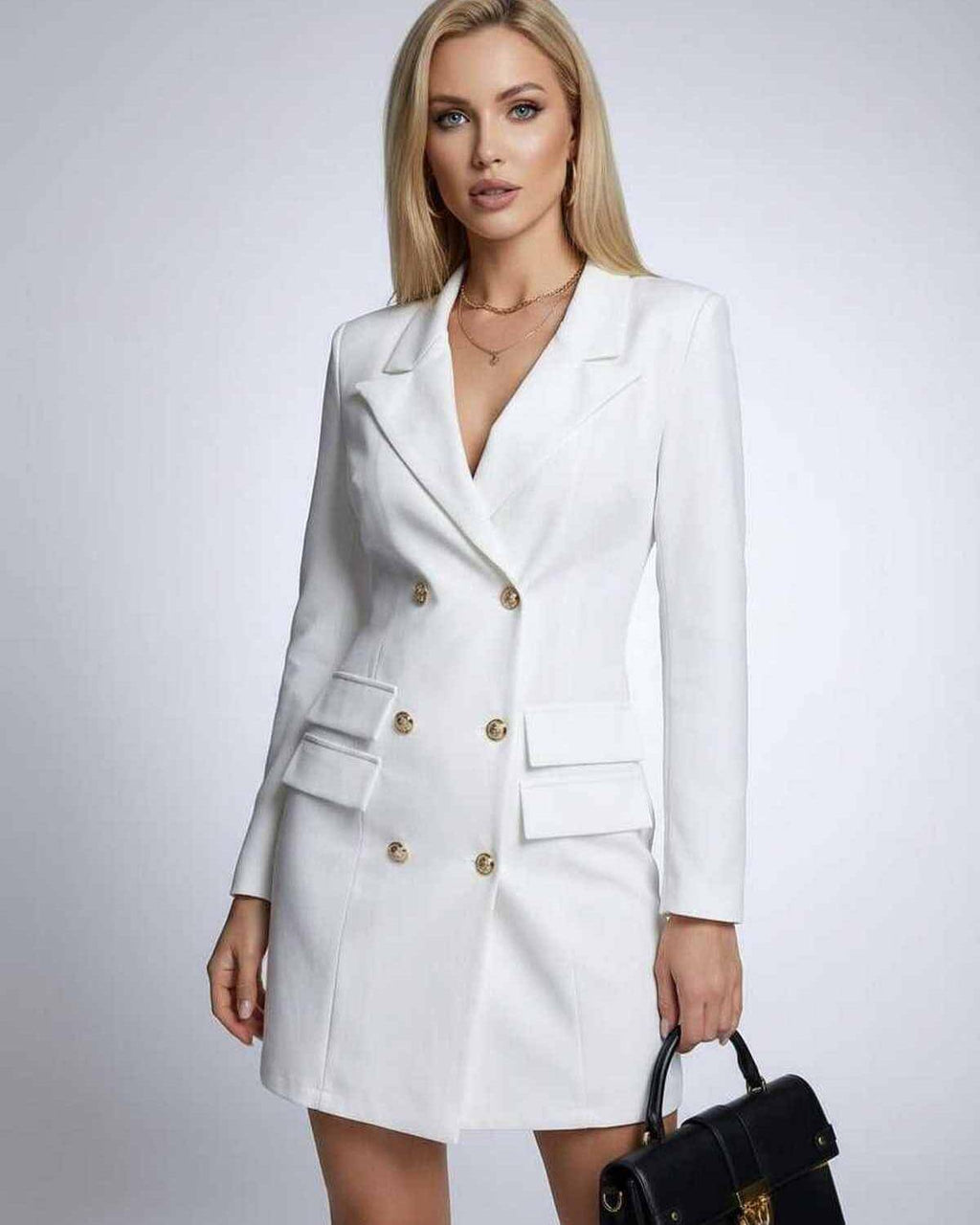 Model wearing the Nova Mini Dress by Lauven, a white double-breasted blazer dress with V-neck and long sleeves.