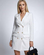 Model wearing the Nova Mini Dress by Lauven, a white double-breasted blazer dress with V-neck and long sleeves.