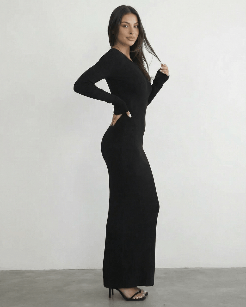Model wearing the Nyx Maxi Dress by Lauven, a long sleeve black dress featuring an open back detail.