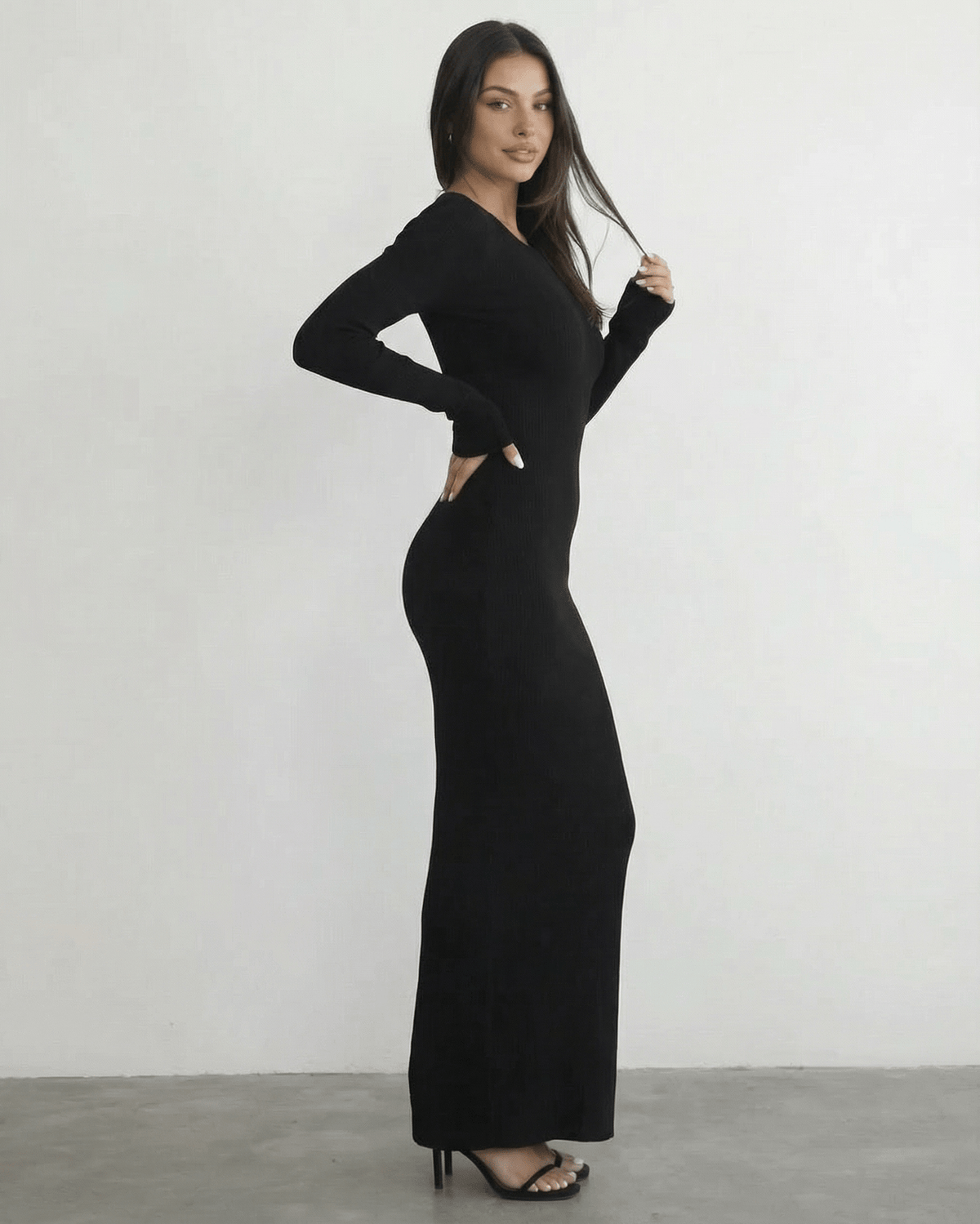Model wearing the Nyx Maxi Dress by Lauven, a long sleeve black dress featuring an open back detail.