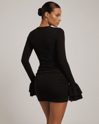 Orion Mini Dress by Lauven showcased in black, featuring ruffled sleeves and a bodycon silhouette from the back.