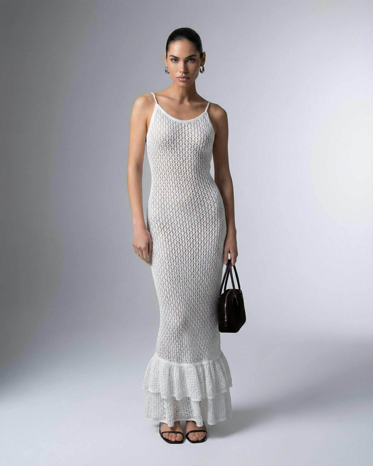 Pearl Maxi Dress by Lauven worn by a model, featuring a hollow-out knit texture and flared hem design.