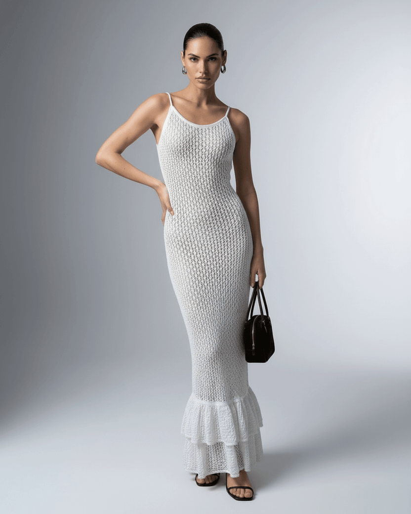 Lauven Pearl Maxi Dress displayed on a model, featuring a white hollow-out bodycon design and ruffled hem.