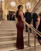 Ruby Maxi Dress by Lauven, elegant deep red sequin gown on model at event stairs, capturing glamour and sophistication.