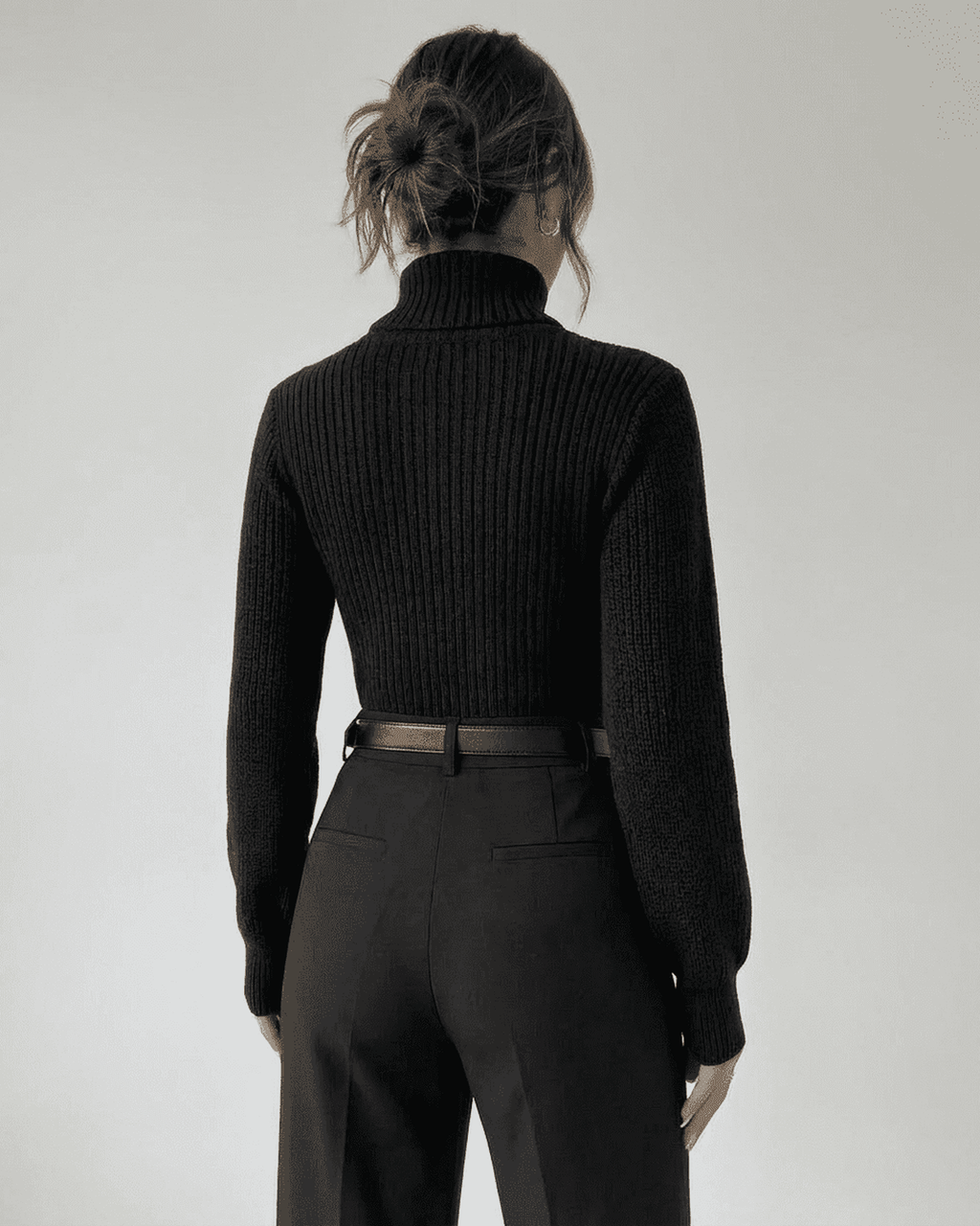 Woman wearing the Sarina Sweater by Lauven, showcasing the back view of the chic hollow out mock neck design.