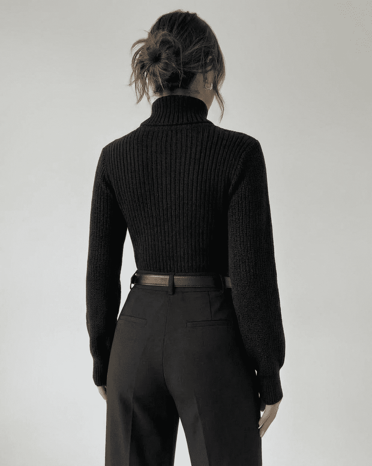 Woman wearing the Sarina Sweater by Lauven, showcasing the back view of the chic hollow out mock neck design.