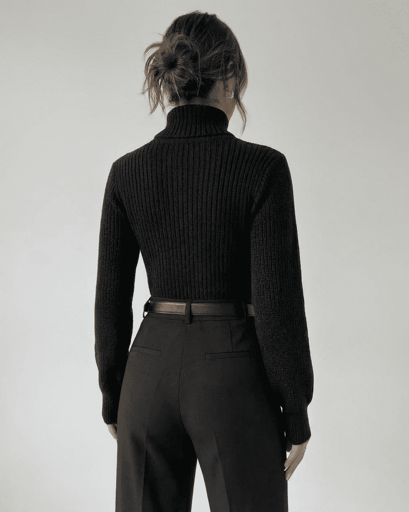 Woman wearing the Sarina Sweater by Lauven, showcasing the back view of the chic hollow out mock neck design.
