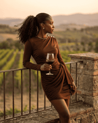 Sienna Mini Dress by Lauven — Stylish woman holding wine in a brown ruched bodycon dress outdoors.