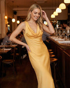 Model showcasing the Solara Maxi Dress by Lauven in a vibrant yellow satin-effect with a cowl neck.