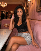 Model wearing Sterling Mini Skirt by Lauven with silver sequin hem, posed elegantly at a chic venue.