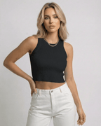 Valencia Top by Lauven, a cropped sleeveless Women's black ribbed knit top styled with high-waisted white trousers.