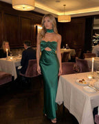 Verde Maxi Dress by Lauven - Luxurious emerald satin fit and flare gown showcased in a chic dining setting.