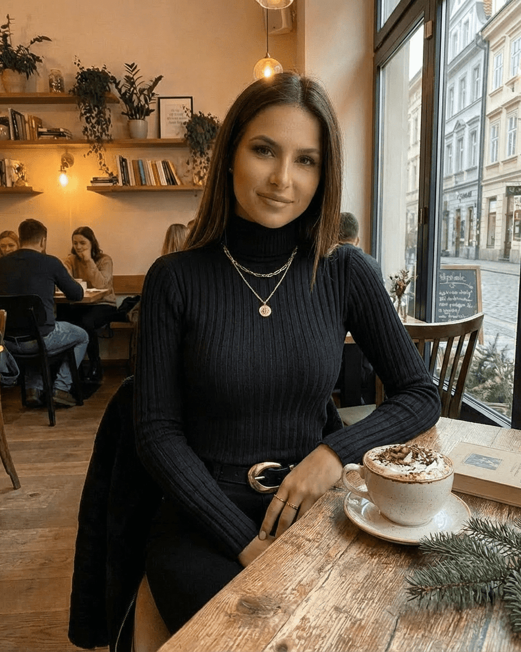 Vesper Sweater by Lauven, a sleek ribbed turtleneck in black showcased with cozy ambiance and warm drink.