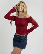 Lauven Valencia Top off-the-shoulder long sleeve top in deep burgundy, styled with denim skirt.