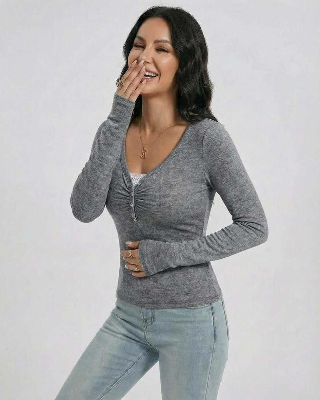 Model wearing the Sterling Pullover by Lauven, a women's slim fit V-neck long sleeve sweater in gray.