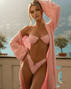 Model wearing the Liora Bikini Set in pink, showcasing sleek design and sculptural details by Lauven.
