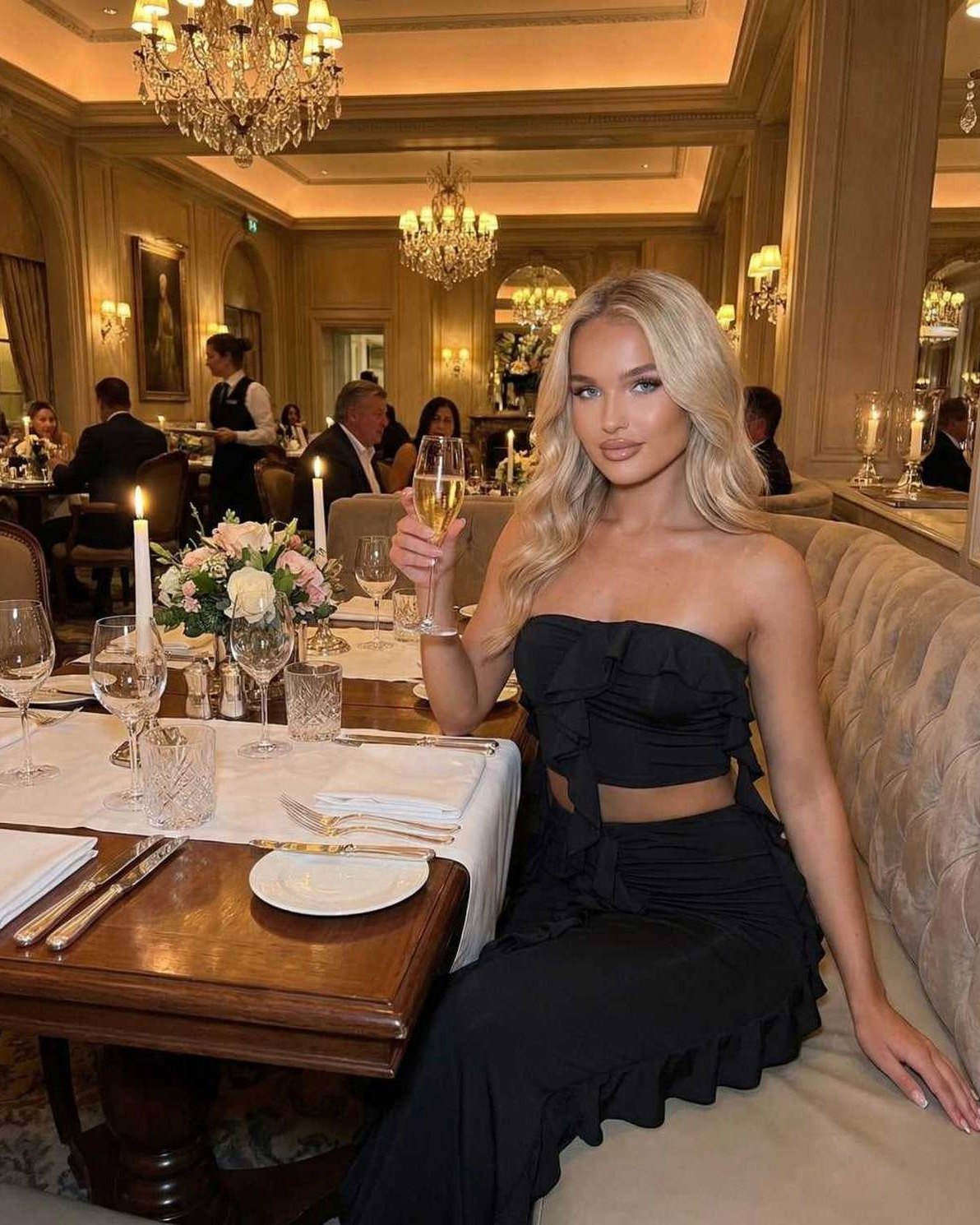 Luna Maxi Dress by Lauven, elegant black sleeveless gown with ruffle detail, worn at a stylish dinner setting.