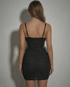 Back view of Luna Mini Dress by Lauven featuring sheer corset detail and ruched black fabric.