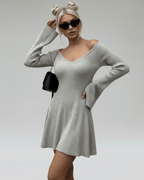 Model wearing the Lauven Luna Mini Dress, a light gray knit with V-neck and flared sleeves, stylish and chic.