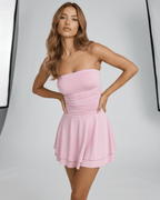 Model wearing Lauven Luna Mini Dress in soft pink, showcasing a strapless style and playful flared skirt.