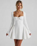 Lauven Luna Mini Dress featuring a square neckline, ruched bow detail, and long fitted sleeves in classic white.