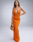 Lunara Maxi Dress in orange, featuring textured polyester blend, halter V-neck, and designed for warm-weather elegance.